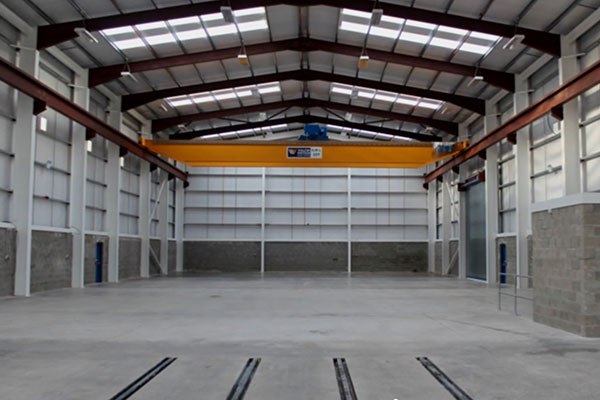 M E Crowe steel-frame warehouse interior with overhead gantry crane